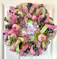 a wreath that says best mom ever with pink flowers and green ribbons on the front door