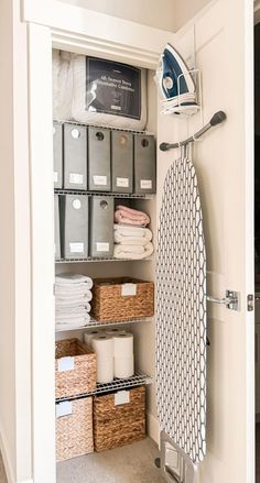 an ironing board and some baskets in a closet