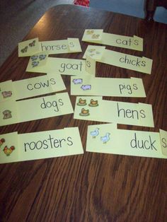 several pieces of paper cut out to spell words on a wooden table with cats and dogs