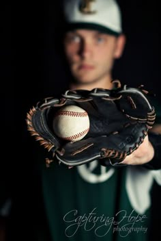 a baseball player holding a ball in his mitt