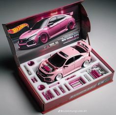 a pink toy car in a box with accessories