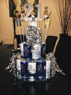 a cake made to look like cans of beer on top of a table with silver decorations