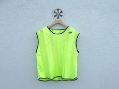 a neon yellow vest hanging on a white wall