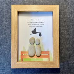 two rocks sitting on top of a wooden frame next to a black bird flying over them