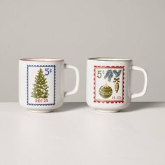 two coffee mugs sitting on top of a white countertop next to each other