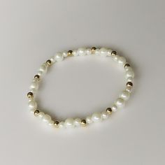 This delicate bracelet features 4mm white glass beads paired with gold spacer beads, creating a classic and elegant look. Measuring 6.5 inches, it's perfect for adding a subtle touch of sophistication to any outfit Elegant White Beaded Bracelets With 8mm Beads, Classic White Beaded Bracelet, White Classic Beaded Bracelets For Everyday, Elegant White Pearl Bracelet With Spacer Beads, White Classic Beaded Bracelets, Everyday White Pearl Bracelet With Extender, Classic White Hypoallergenic Beaded Bracelets, Classic Hypoallergenic White Beaded Bracelets, Everyday White Beaded Rosary Bracelet