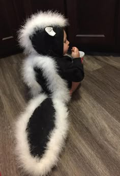 a baby is sitting on the floor with a stuffed animal in it's arms