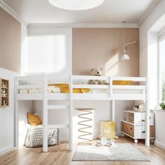 a white bunk bed sitting in a bedroom next to a dresser and window on top of a hard wood floor