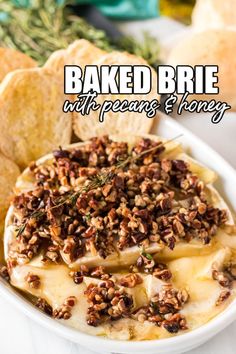 baked brie with pecans and honey in a white bowl next to crackers