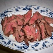 some meat is sitting on a blue and white plate