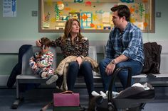 a man and woman sitting on a bench next to a child in a waiting area