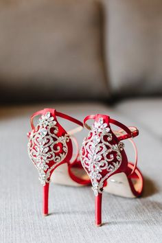 a pair of red high heeled shoes sitting on top of a couch