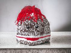 a brown and white knitted hat sitting on top of a counter next to a wall