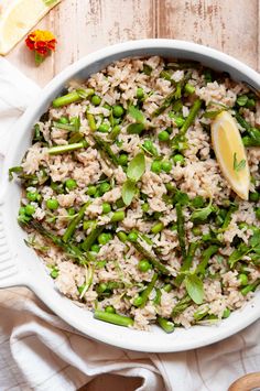 a bowl filled with rice and asparagus on top of a white table cloth