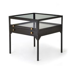 a glass and metal end table with drawers