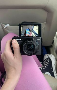 a person is taking a photo in the back seat of a car with a camera