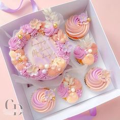 cupcakes with pink frosting and flowers in a white box on a pink background