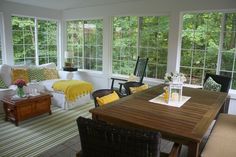 a sun room with couches, chairs and tables