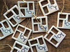 white ceramic ornament with word joy to you written on them hanging from strings