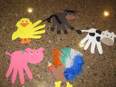 paper cutouts of farm animals and birds on a counter top with lights in the background