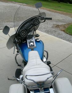 a blue motorcycle parked on top of a sidewalk