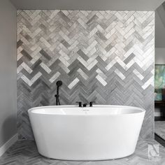 a white bath tub sitting in a bathroom next to a mirror on the wall above it