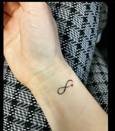 a woman's wrist tattoo with an infinite symbol on it