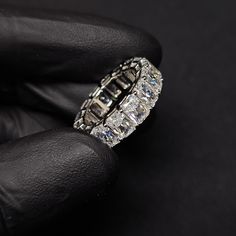 a close up of a person's hand wearing a ring with diamonds on it