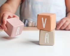 a child playing with wooden blocks that spell out the word v and a block shaped like a letter