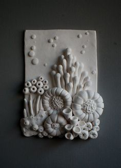 an art piece made out of clay with flowers on it