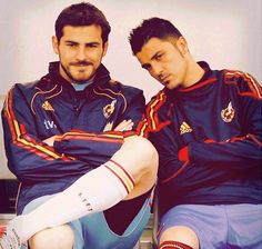 two men sitting next to each other with their legs wrapped around the ankles and wearing soccer socks