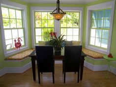 a dinning room with green walls and wooden floors