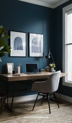 a home office with blue walls and artwork on the wall