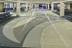 an empty airport terminal with chairs and desks in the middle of the floor,