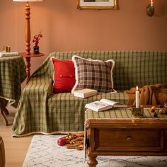 a living room filled with furniture covered in blankets and plaid throw pillows next to a coffee table