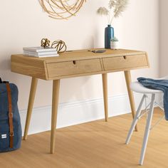 a wooden desk sitting next to a wall with a blue bag on top of it