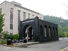 the coal house is located in front of a large building with an american flag hanging from it's roof