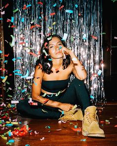 a woman sitting on the floor surrounded by confetti