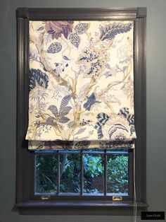 a window with a flowered curtain hanging on it's side