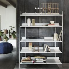 a white shelf with books and vases on it