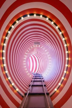 a red and white striped tunnel with lights