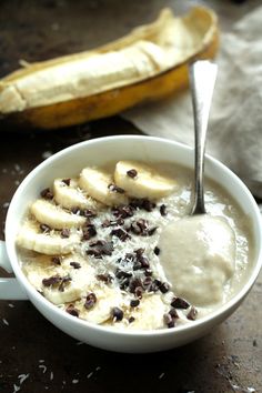 a bowl of oatmeal with bananas and raisins on the side