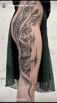 a woman's leg with a tattoo on it and a castle in the background