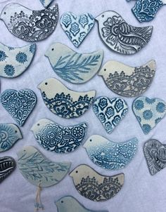 blue and white ceramic birds are on a tablecloth with other decorative items in the background