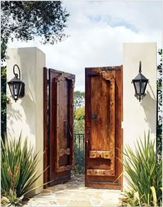 two wooden doors open in front of a white building