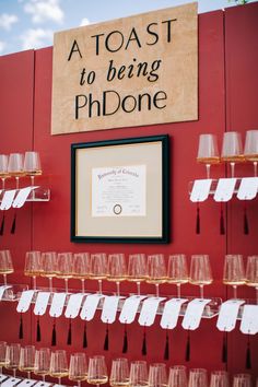 there are many wine glasses on display in front of a sign that says, a toast to being ph donee