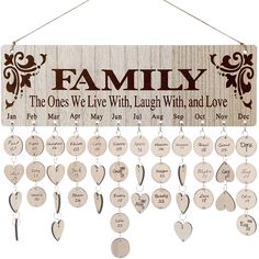 a wooden family sign hanging on a wall with hearts and names attached to the strings