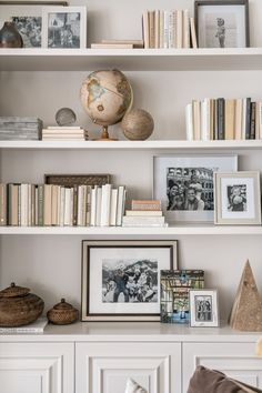 the bookshelves are filled with pictures and other decorative items, such as an ornament