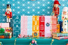 colorful christmas decorations and nutcrackers are displayed on a blue tableclothed wall