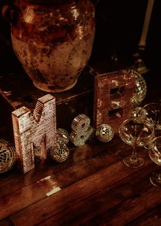 a wooden table topped with lots of different types of glassware and knick knacks